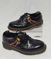 Side profile of both shoes showing Basquiat graphic and overall condition