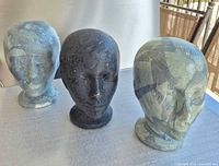 Front view of three styrofoam mannequin heads showing finishes and condition