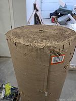 Large roll of single-face corrugated cardboard standing upright