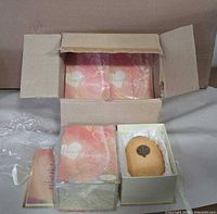 Open master carton showing four boxed candleholders, one box open revealing candleholder