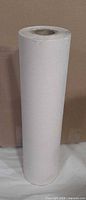 Full view of unused masking paper roll standing upright