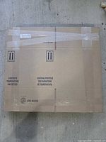 Stack of flattened cardboard boxes bundled with tape showing printing and size