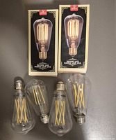 Six clear glass squirrel cage bulbs with two in original Globe boxes and four loose
