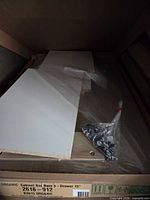 Flat-packed cabinet base panels and sealed hardware bag inside original carton