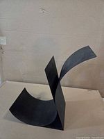 Front angle of black curved metal display/bookend