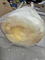 Rolled white/yellow foam wrapped in clear plastic