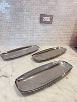 Three Alfra/Alessi stainless long trays on countertop