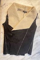 Front view of black and cream faux shearling vest