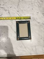 Front view of dark green frame with ruler showing width