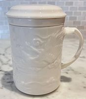 Mug assembled with lid on, showing embossed dragon