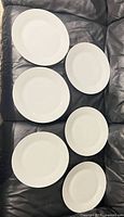 Six white dinner plates front view