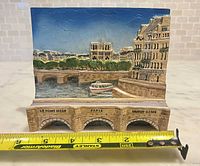 Front view of plaque showing full scene and measuring tape for width