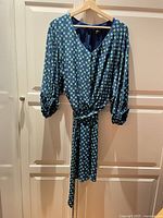 Full view of dress on hanger showing style, belt, sleeves