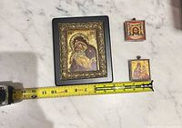 Front view of plaque and two small icons with tape measure