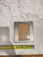 Front view of silver-tone metal frame on marble surface