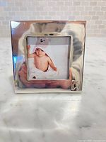 Front view of silver-tone square photo frame with teddy bear motif