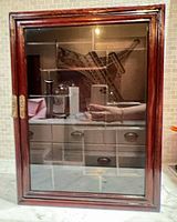 Front view of closed cabinet showing glass door and wood frame