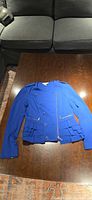 Full view of front of royal blue Bianca Nygard jacket on table