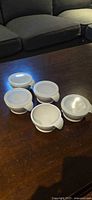 Five silicone bowls with lids displayed on table
