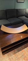 Curved wooden balance board on coffee table, showing overall shape