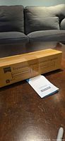 Closed retail box labeled “Expandable Drawer Dividers Organizer” on tabletop