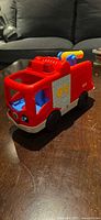 Front angled view of red Little People fire truck showing cab and side panel