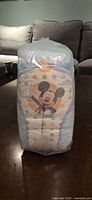 Front view of one sealed diaper pack showing Mickey graphic and size 5 marking
