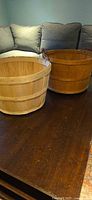 Two wooden bushel baskets on table, lighter and darker tones visible