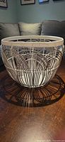Angled view of round white wire basket showing weave design