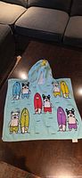 Front view of hooded poncho towel laid flat showing full print
