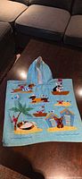 Front view of hooded towel laid flat showing hood and appliqué design