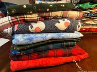 Stack of six folded flannel yards showing assorted prints and colors