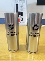 Front view of both silver cylindrical Star Sticks tins showing NHL logo, text and 2006-2007 date.