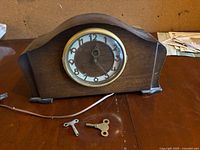 Front view of Bellevue electric tambour mantel clock with two metal keys