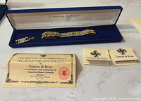 Bracelet inside blue Camrose & Kross case with certificate and papers visible