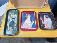 All three Coca-Cola trays on table