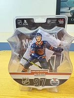 Front view of Connor McDavid action figure in shield-shaped blister packaging