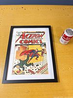 Front view of framed Action Comics No. 7 reproduction poster beside soda can for scale