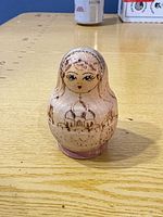 front view of nesting doll with cathedral motif and face