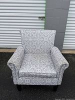 Front view of gray patterned armchair showing overall style and condition