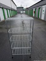 Front view of one chrome wire shelving unit showing five shelves and casters