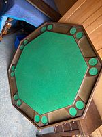 Top view of octagonal table showing green felt playing surface and recessed holders