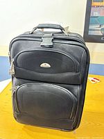 Front view of suitcase showing logo, pockets, handle