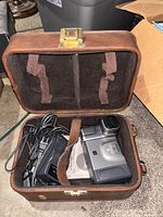 Camcorder, charger, manual and accessory inside brown felt-lined case