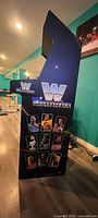 Side view of blue WWE WrestleFest arcade cabinet with graphics