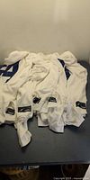Stack of white mesh jerseys showing one printed number