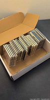 Open cardboard box with approximately 24 jewel-case CDs