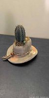 Front view of ceramic cowboy hat planter with cactus