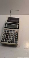 Front view showing Canon P1-DH III printing calculator, keypad, display and paper roll arm