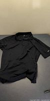 Front view of black Nike Golf polo shirt